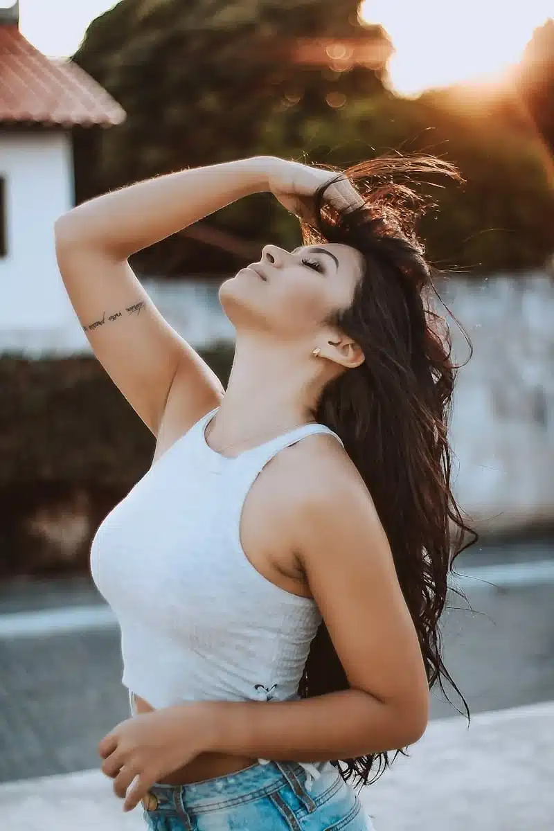 Photo by Caique Nascimento woman wearing white tank crop top