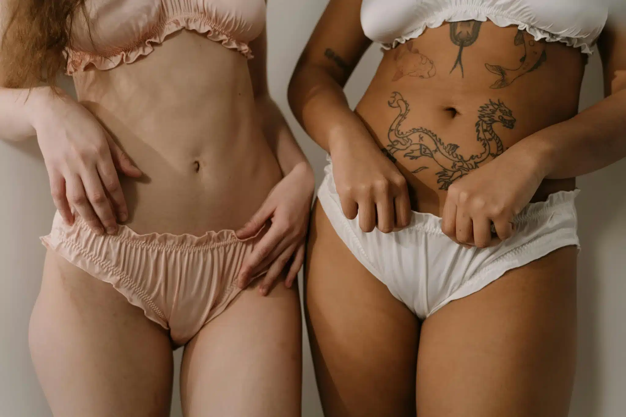 Two women in intimate clothing pose